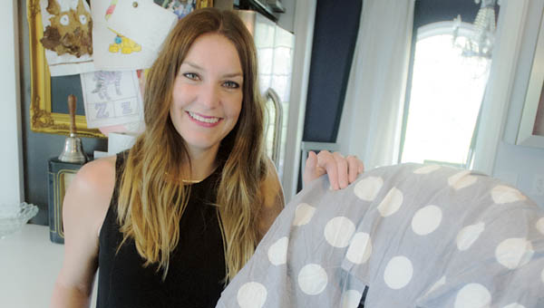 Rome Township resident Maggie Gue with her invention Save Your Seat. The disposable cover is placed over your child’s car seat and will aid in spills and wear on the car seat.