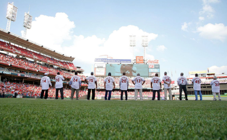 Members of the 1976 World Champion Cincinnati Reds lined up along the first base line before Friday’s game as they were honored with a 40th reunion. Player are watching a tribute to the team that was played on the scoreboard. (Photo Courtesy of The Cincinnati Reds.com/Kirk Irwin – Getty Images)