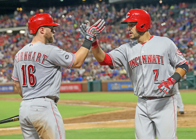 The Cincinnati Reds' Eugenio Suarez (7) is congratulated by teammate Tucker Barnhart after hitting a three-run home run in the eighth inning against the Texas Rangers on Wednesday at Globe Life Park in Arlington, Texas. The Rangers won, 6-4. (Steve Nurenberg/Fort Worth Star-Telegram/TNS)