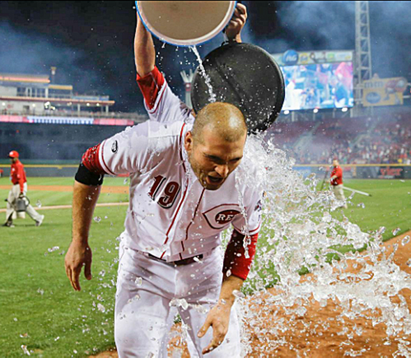 Cincinnati Reds’ first baseman Joey Votto is doused with a water cooler by teammate Ivan De Jesus Jr. after hitting a walk-off home run on Tuesday in a 7-6 win over the St. Louis Cardinals. (Photo Courtesy of The Cincinnati Reds.com/John Minchillo — AP)