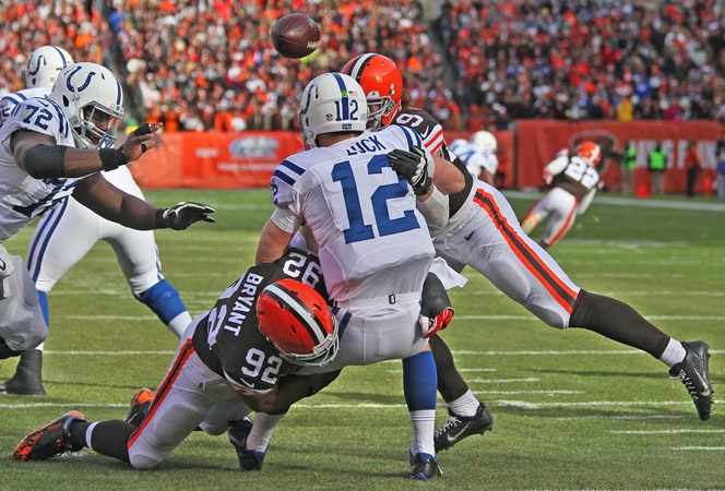 Cleveland Browns defenders Paul Kruger, right, and Desmond Bryant, left, hit Indianapolis Colts quarterback Andrew Luck during a game last season. Bryant suffered a torn pectoral muscle and will miss the upcoming season. (Ed Suba Jr./Akron Beacon Journal/TNS)