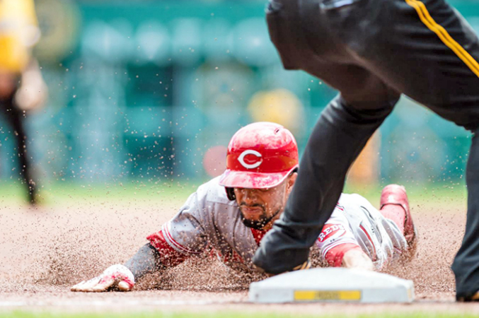Cincinnati Reds’ Billy Hamilton steals third base during the first inning of Sunday’s game. Hamilton stole four bases, scored three runs and had three hits as the Reds beat the Pittsburgh Pirates 7-3. (Courtesy of the Cincinnati Reds.com/Justin Berl — Getty Images)