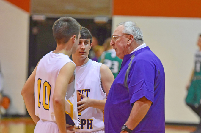 Long-time high school coach Rex Cooksey (right) talks with Tre Neal (10) and Peyton Adkins during a recent game. Cooksey coached in Kentucky for 40 years but came out of retirement this season to take over as the St. Joseph Flyers’ head basketball coach. (Kent Sanborn of Southern Ohio Sports Photos)