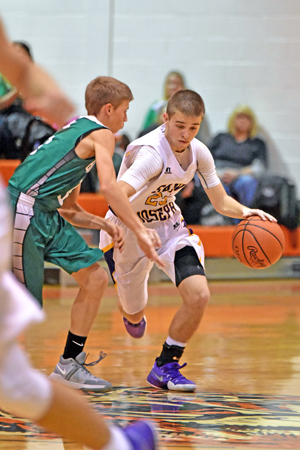 St. Joseph Flyers’ guard Tre Neal (right) dribbles the ball across midcourt against the Green Bobcats’ defense during Saturday’s game. The Flyers won 60-48. (Kent Sanborn of Southern Ohio Sports Photos)