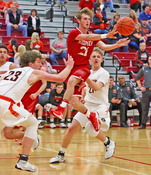 Rock Hill Redmen guard Tim Adkins (21) fires a pass to an open teammate during during Wednesday’s Division III sectional tournament game at Jackson. The Redmen lost to Wheelersburg, 61-44. (Tim Gearhart of Tim’s News & Novelties, Park Ave. in Ironton)
