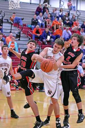 Coal Grove Hornets’ Nate Harmon (10) and Cory Borders (2) battle Nelsonville-York’s Patrick Gail for a rebound during Monday’s Division III sectional tournament game. Coal Grove won 49-34 to advance to the sectional finals at 6 p.m. on Friday. (Tim Gearhart of Tim’s News & Novelties, Park Ave. in Ironton)